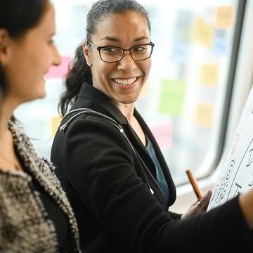 Frau lachend vor Whiteboard