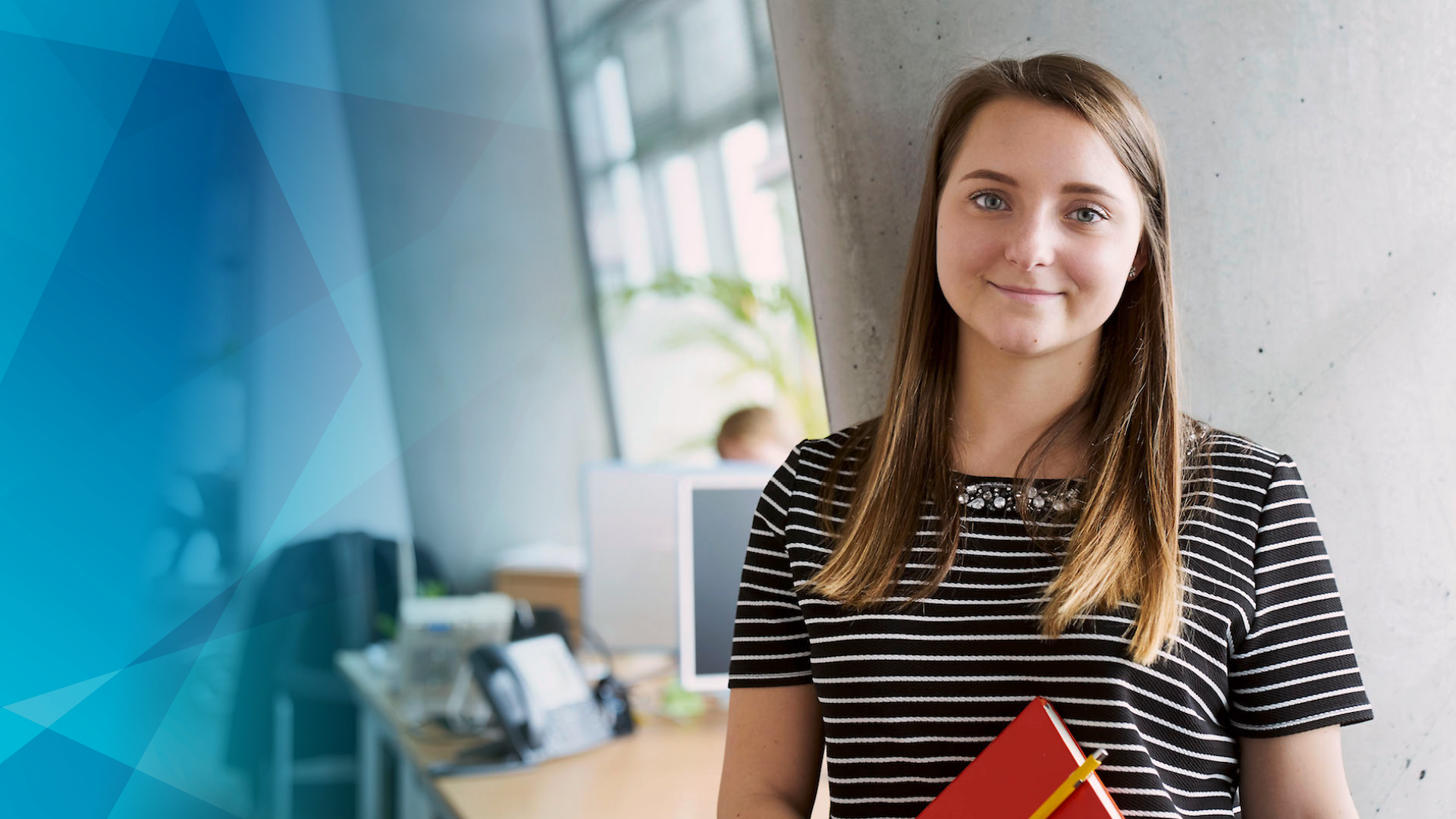 Schülerin im Büro mit rotem Buch in der Hand