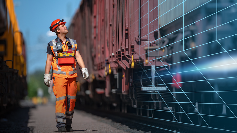 Ein DB-Mitarbeiter mit orangener Latzhose und Helm laufend zwischen zwei Güterzügen