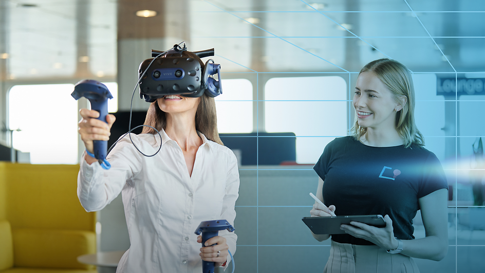 Woman with VR glasses next to woman with tablet