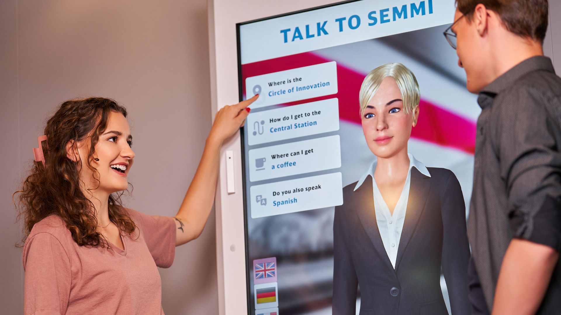 Vier Personen sitzend am Tisch mit Laptop, Lego-Roboter und Klebezetteln auf dem Tisch