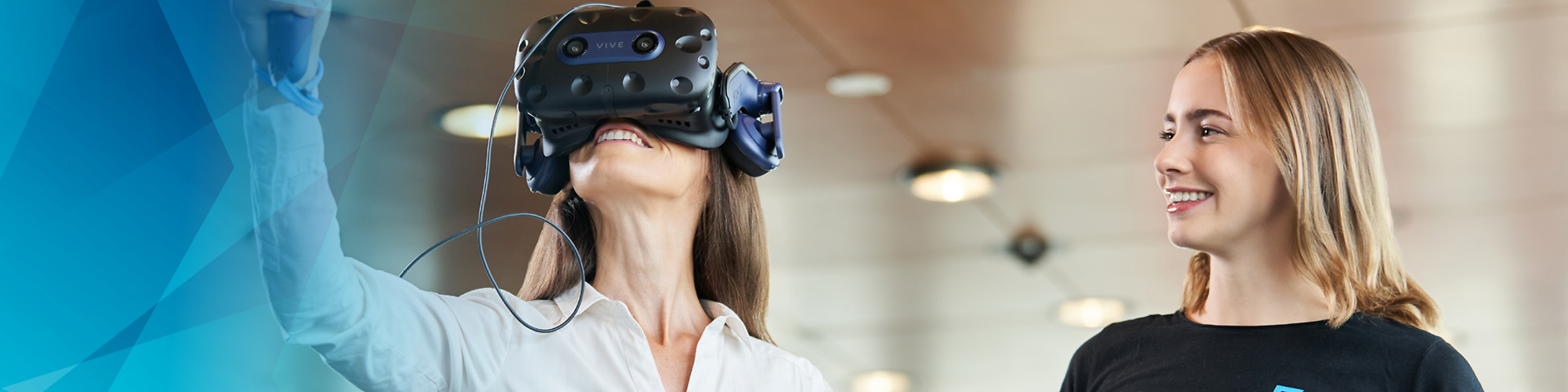 Woman with VR glasses on, next to her a second woman with tablet in hand