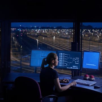 Frau vor Laptop im Stellwerk