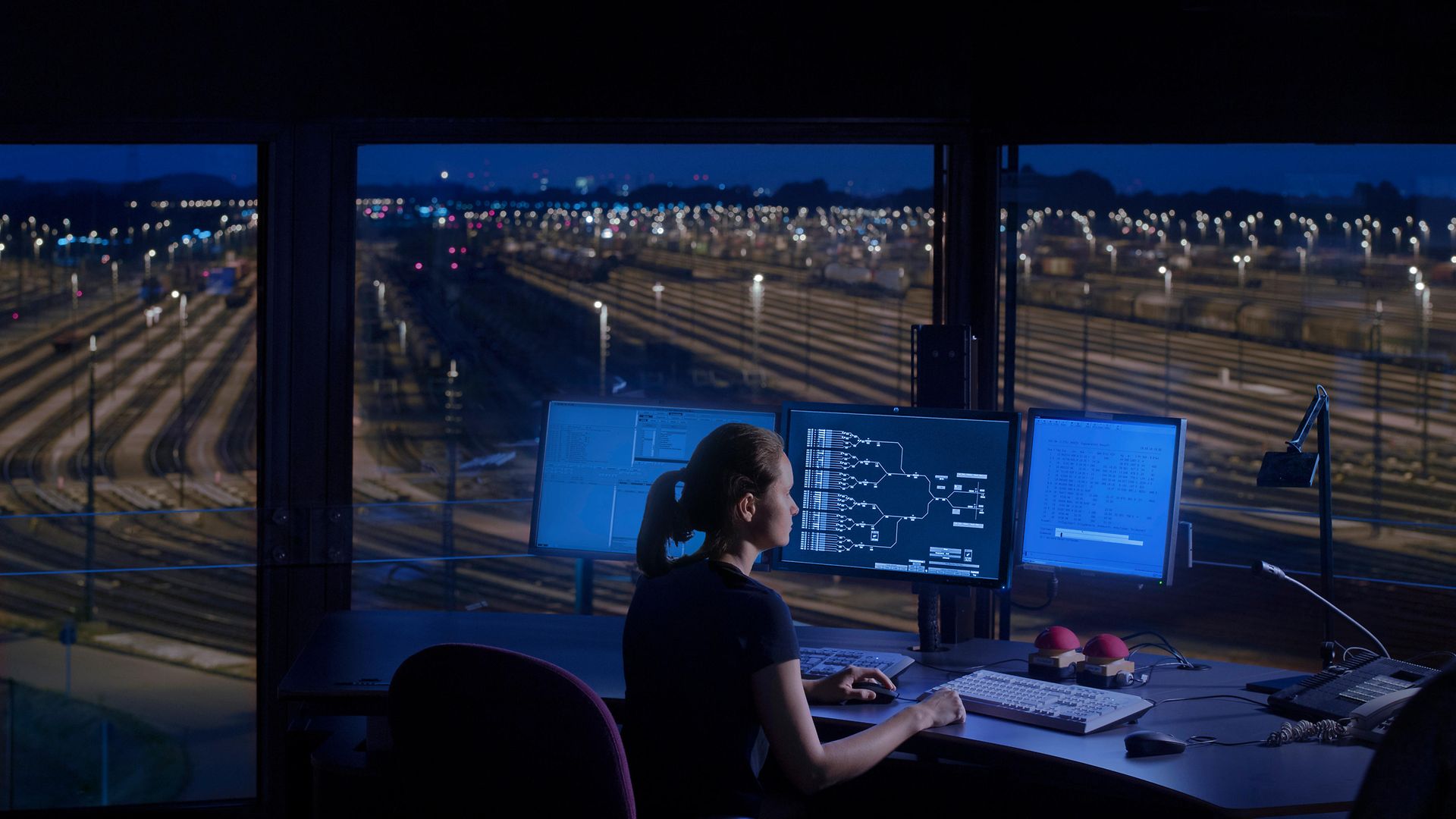 Woman in front of laptop in signal box