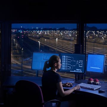 Woman in front of laptop in signal box