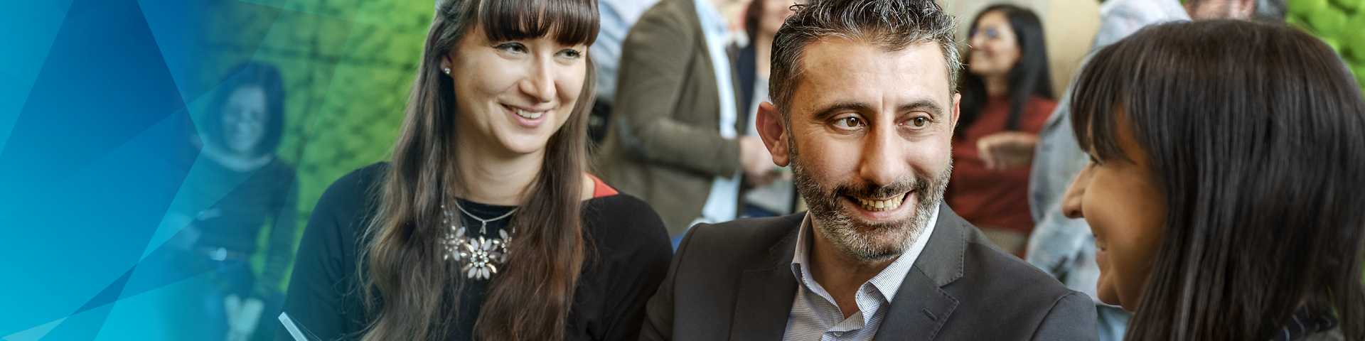 Verschiedene Mitarbeitende in einem Meeting, in ein Tablet blickend