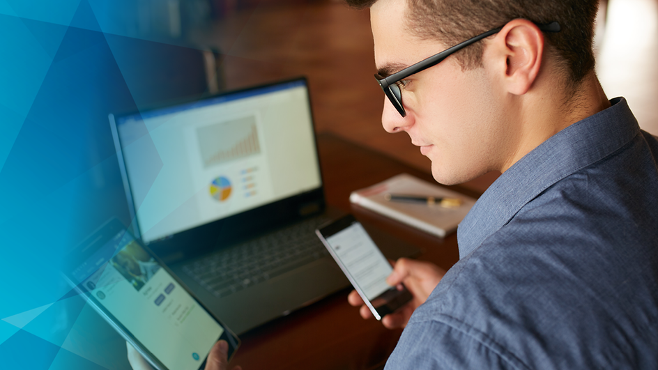 Mann mit Brille vor Laptop, Handy und Tablet